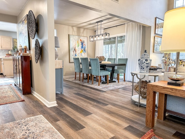 interior space with baseboards, a notable chandelier, and wood finished floors