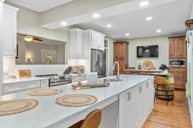 1244 Salem Rd, Havana, FL 32333 - kitchen with sink, ceiling fan, appliances with stainless steel finishes, white cabinets, and a kitchen bar