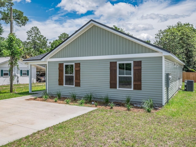 42 Duane Dr, Crawfordville, FL 32327 - view of front facade featuring board and batten siding, a front lawn, and an attached carport