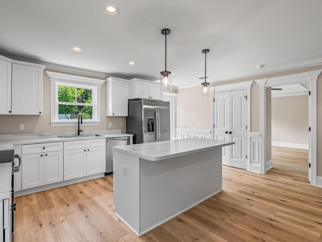 42 Duane Dr, Crawfordville, FL 32327 - kitchen with appliances with stainless steel finishes, light countertops, white cabinetry, a center island, and ornamental molding
