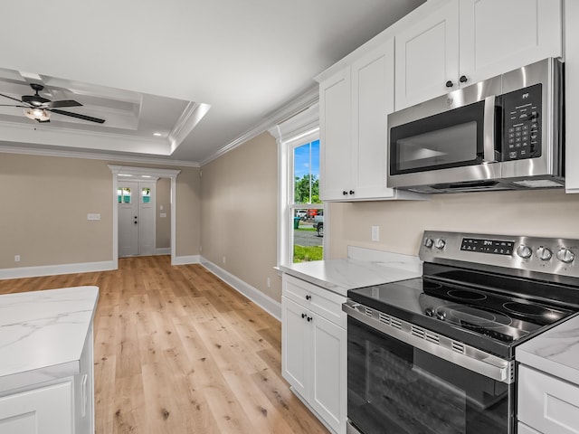 42 Duane Dr, Crawfordville, FL 32327 - kitchen featuring appliances with stainless steel finishes, ornamental molding, light wood-type flooring, a tray ceiling, and white cabinets