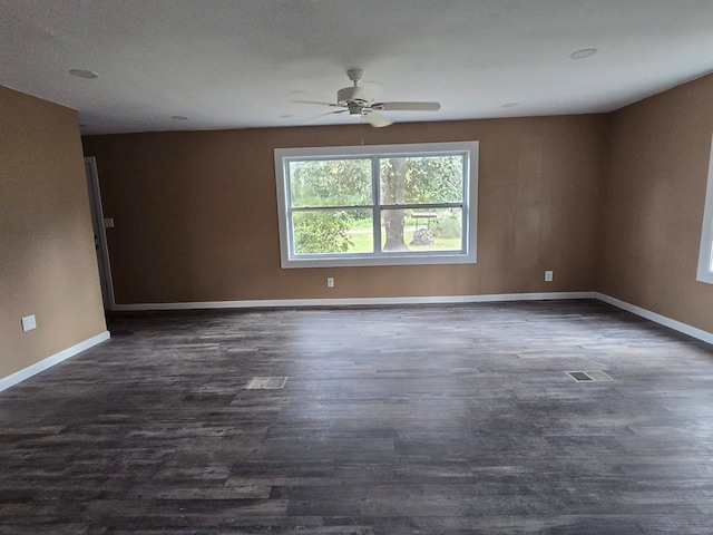 spare room featuring dark wood-type flooring and ceiling fan