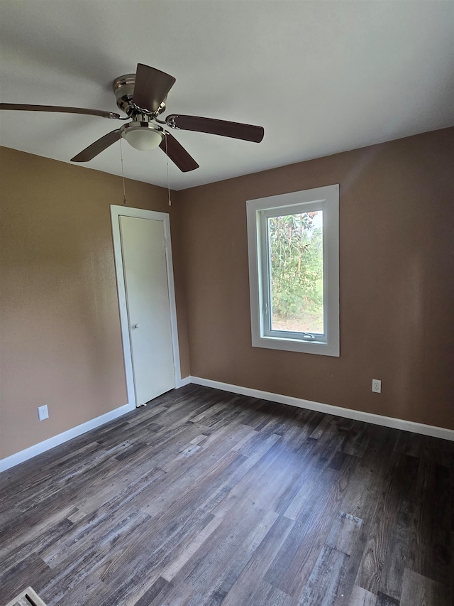 spare room with dark hardwood / wood-style floors and ceiling fan