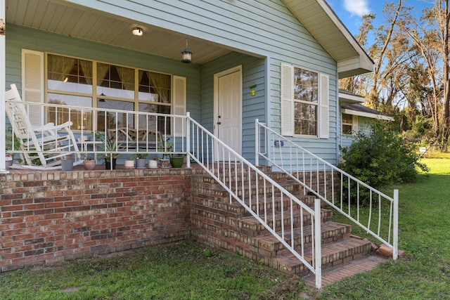 view of exterior entry with a yard