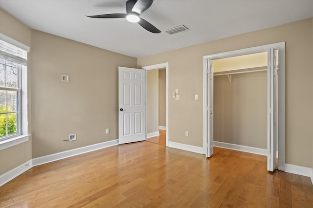 unfurnished bedroom with ceiling fan, wood-type flooring, and a closet