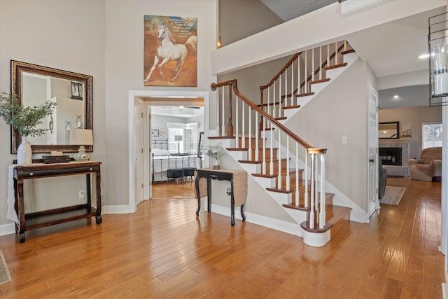 foyer entrance with hardwood / wood-style flooring, a towering ceiling, and a wealth of natural light