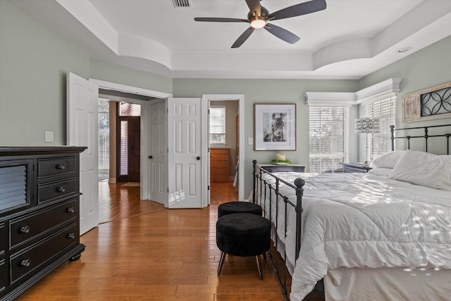 bedroom featuring wood-type flooring and a raised ceiling