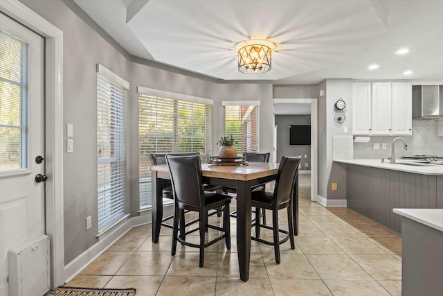 tiled dining space with sink and a notable chandelier