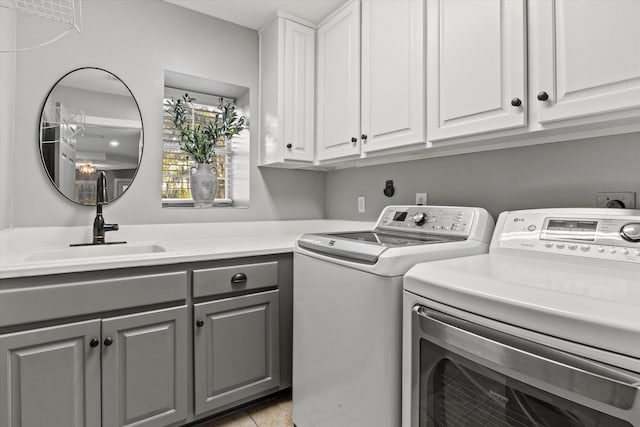 clothes washing area featuring independent washer and dryer, cabinets, light tile patterned flooring, and sink