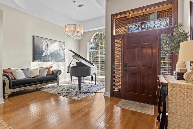 entrance foyer featuring wood-type flooring and a chandelier