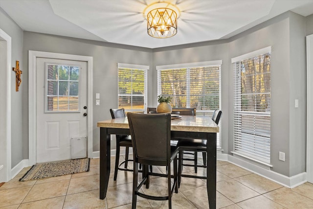 dining space with light tile patterned flooring and a chandelier