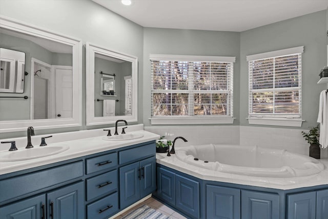 bathroom with tile patterned flooring, vanity, a healthy amount of sunlight, and a bath