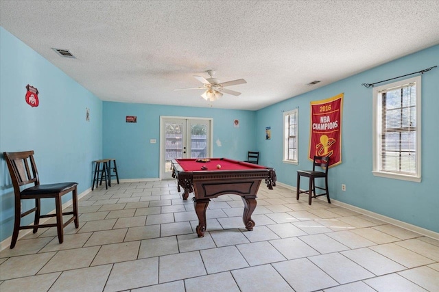 rec room featuring light tile patterned flooring, a textured ceiling, ceiling fan, and french doors