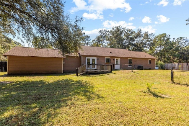 rear view of property featuring cooling unit, a lawn, and a wooden deck