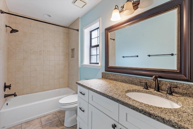 full bathroom featuring vanity, tile patterned floors, toilet, and tiled shower / bath