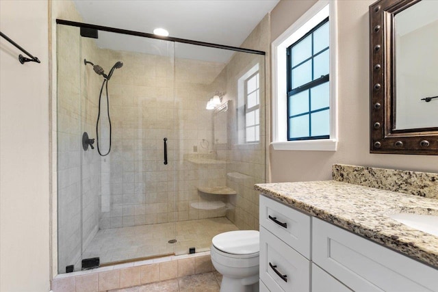 bathroom with vanity, tile patterned floors, toilet, and a shower with shower door