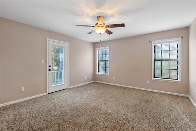 carpeted empty room featuring plenty of natural light and ceiling fan