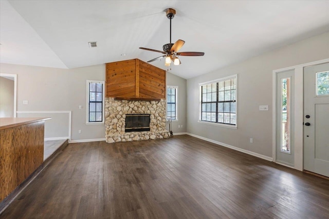 unfurnished living room with a wealth of natural light, dark hardwood / wood-style floors, and vaulted ceiling