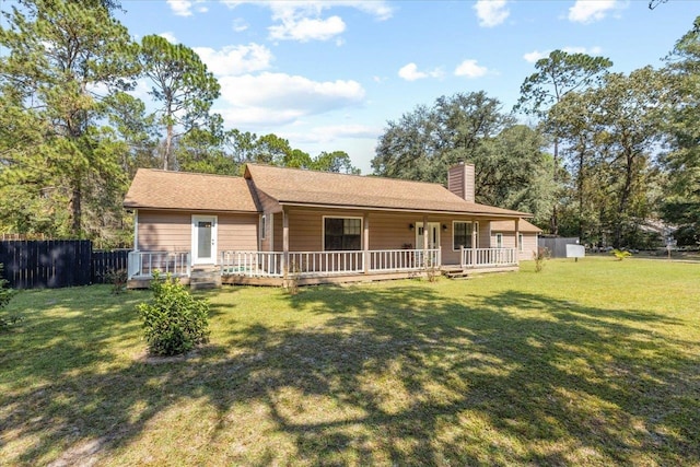 back of house with a lawn and a wooden deck