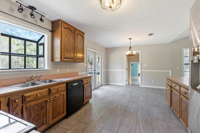 kitchen with black dishwasher, a chandelier, sink, light wood-type flooring, and decorative light fixtures