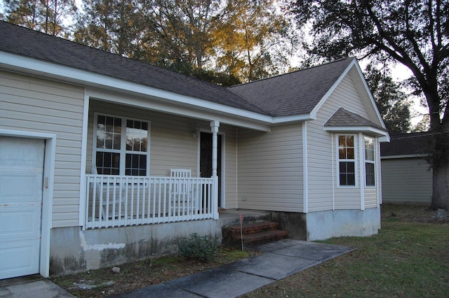 ranch-style home featuring a porch and a garage