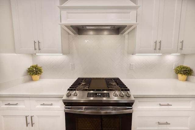 kitchen with white cabinets, stainless steel gas range oven, and custom exhaust hood