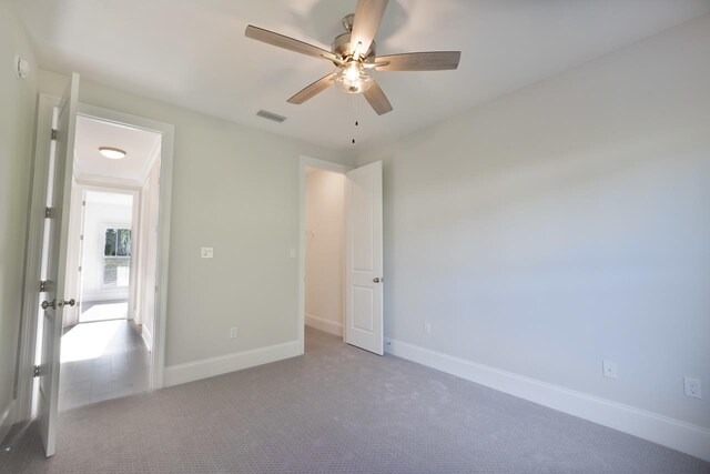 unfurnished bedroom featuring ceiling fan and light colored carpet