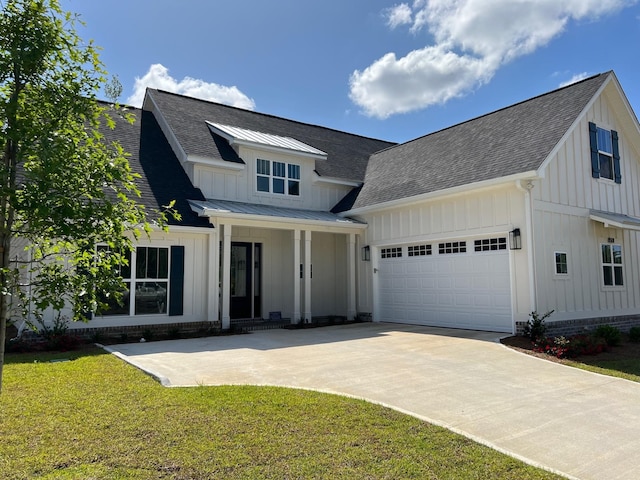 modern farmhouse featuring a front yard and a garage