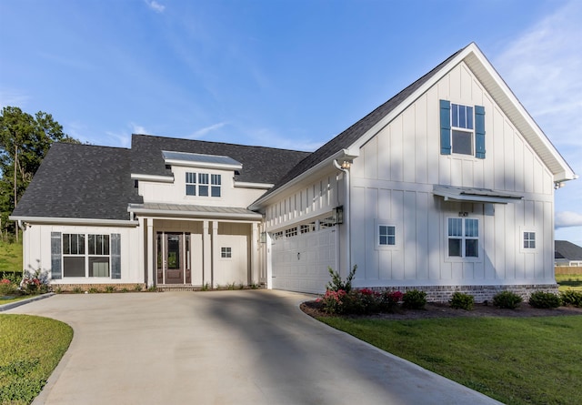 modern farmhouse featuring a front yard and a garage