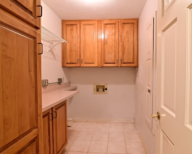 washroom featuring hookup for a washing machine, cabinets, and light tile patterned flooring