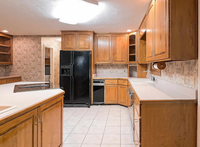 kitchen with black refrigerator with ice dispenser, sink, light tile patterned floors, and a textured ceiling