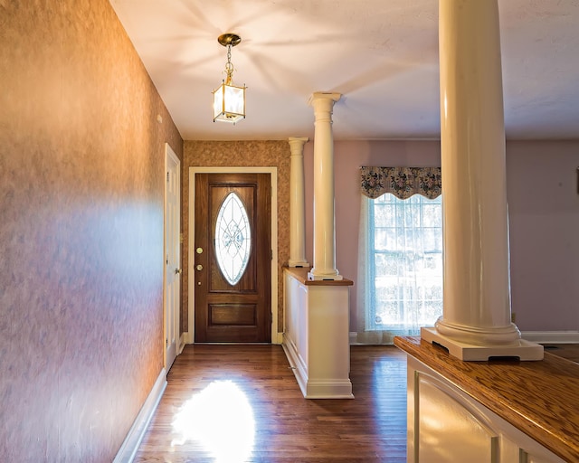 entryway featuring dark hardwood / wood-style flooring and decorative columns