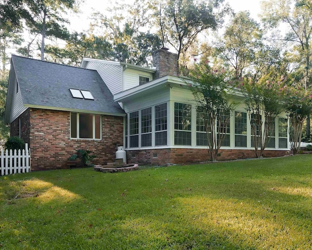 back of house with a sunroom and a yard