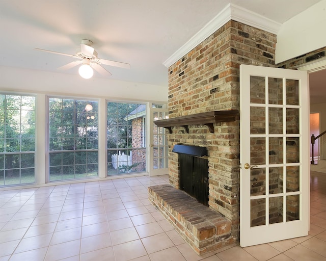 unfurnished living room with a fireplace, ceiling fan, light tile patterned floors, and crown molding