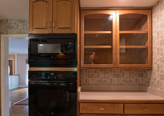 kitchen with black appliances and hardwood / wood-style flooring