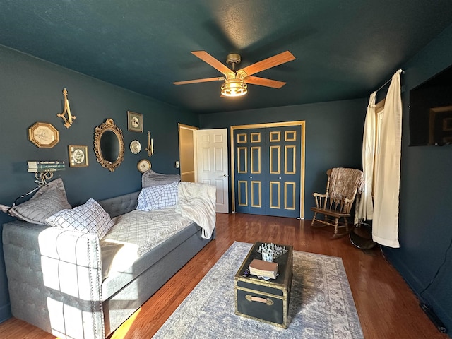 living area with a ceiling fan and dark wood-type flooring