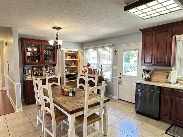 dining room featuring light tile patterned floors, a textured ceiling, baseboards, and a notable chandelier