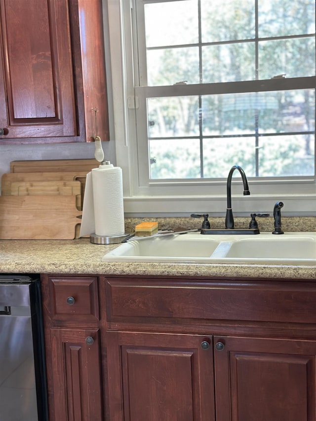 kitchen with light countertops, dark brown cabinets, a sink, and a wealth of natural light