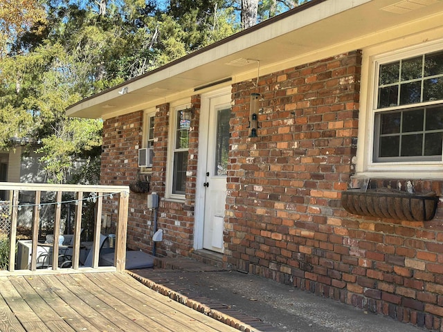 property entrance featuring brick siding and a deck