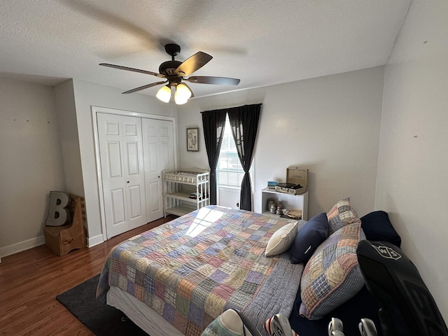 bedroom with a closet, dark wood-type flooring, a ceiling fan, a textured ceiling, and baseboards