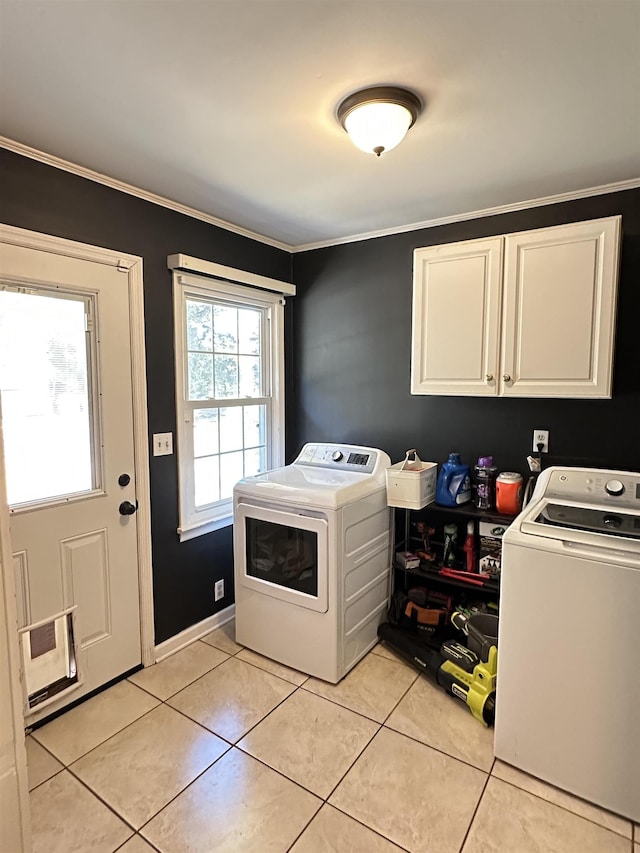 clothes washing area featuring light tile patterned floors, washing machine and clothes dryer, cabinet space, and crown molding