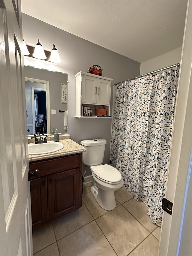 full bathroom with toilet, vanity, and tile patterned floors