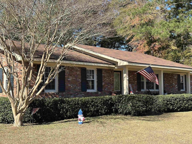 ranch-style house with brick siding and a front yard