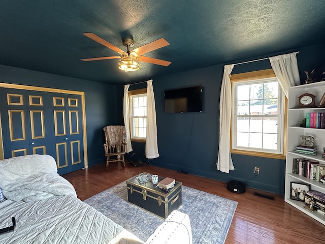 living room with visible vents, dark wood-style flooring, and a wealth of natural light