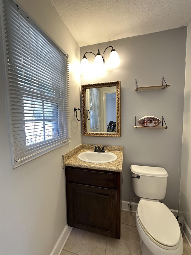 bathroom featuring a textured ceiling, toilet, vanity, and baseboards