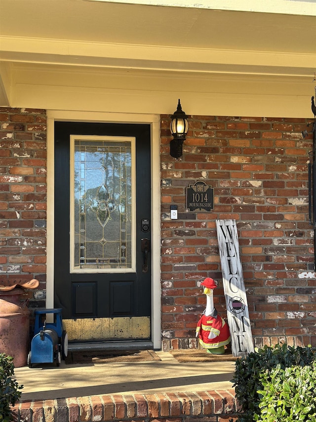 doorway to property featuring brick siding