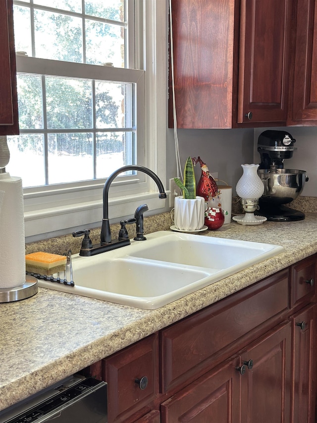 kitchen with light countertops, a sink, and dishwasher