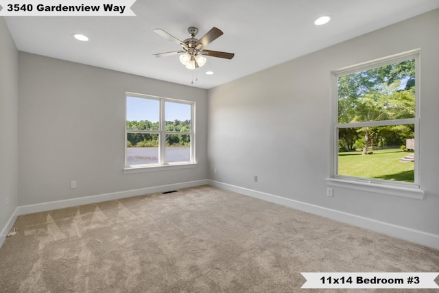 unfurnished room with plenty of natural light, ceiling fan, and light colored carpet