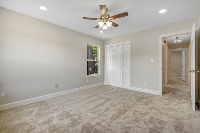 unfurnished bedroom featuring ceiling fan, light carpet, and a closet