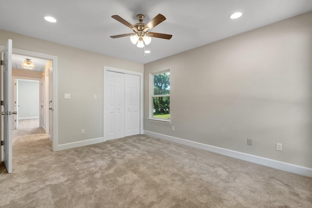 unfurnished bedroom featuring a closet, light colored carpet, and ceiling fan